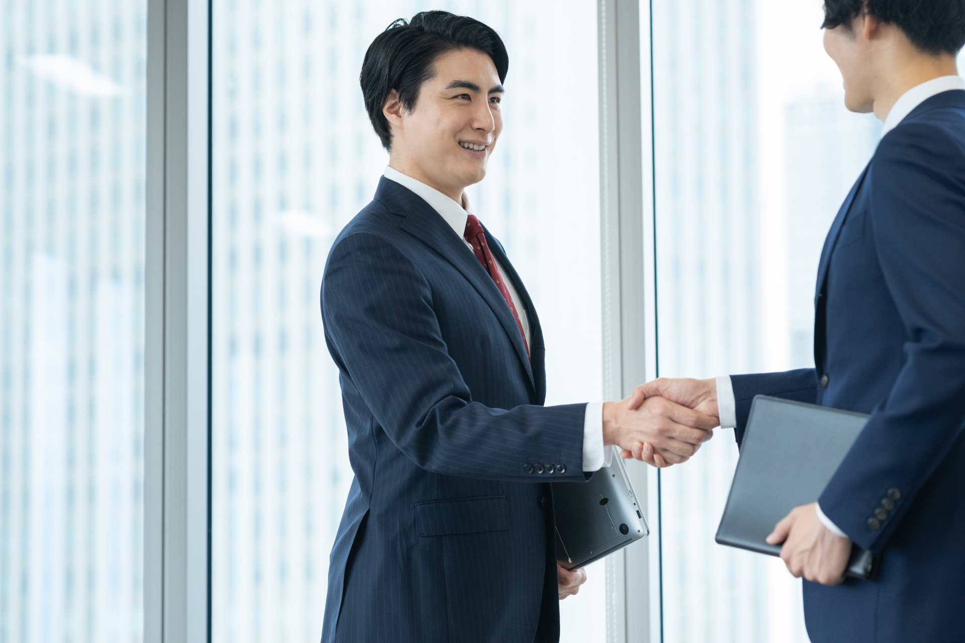 ビジネスの場で握手を交わす二人
